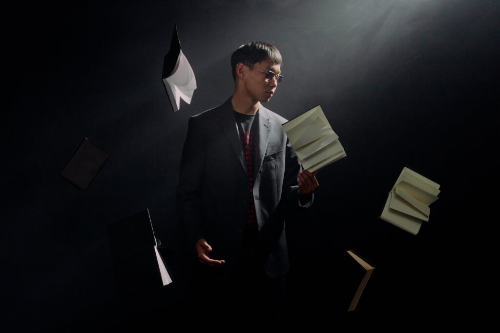 Man in Black Suit Holding White Printer Paper